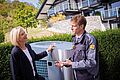 Das Bild zeigt einen Elektrohandwerker mit Kundin vor Wärmepumpe.